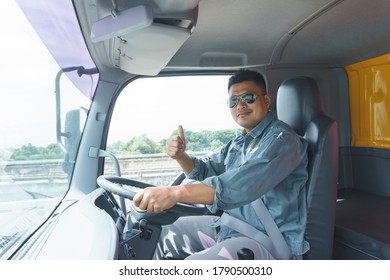 Professional Truck Driver, Adult Male Asian Wearing Sunglasses Smile And Raise Your Hand. The Young Man Worker Is Confident In The Safety Of The Transport  And Delivery Business For A Long Time.