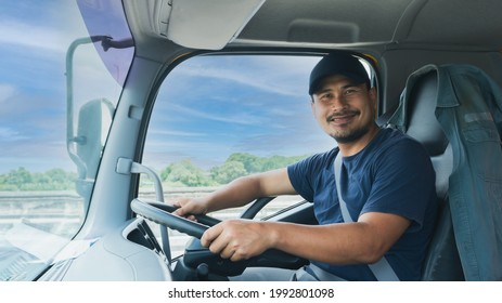 Professional truck driver bearded man smiling confident fasten seat belt While driving. concept business owner Transportation delivery semi-truck