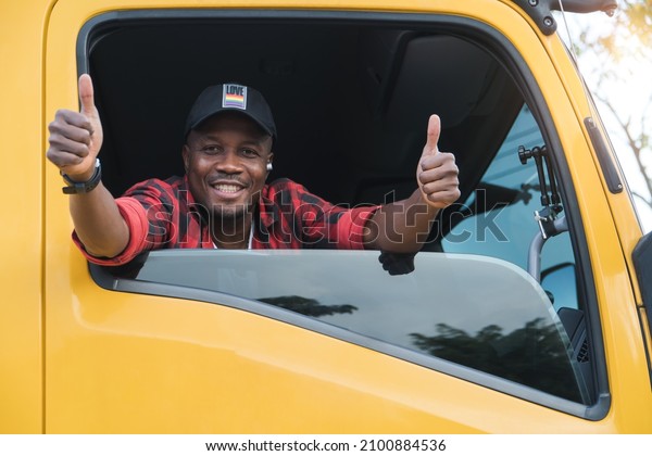 professional truck driver delivery worker in
transportation and delivery business for long time.Young African
American man smiling positive confident thumbs up in truck cargo
insurance service.
