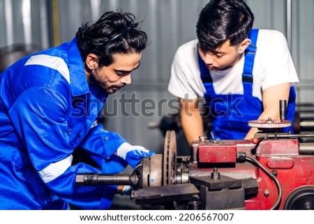 Professional two labor machanic engineer technician worker industrial man wearing blue safety uniform working control with heavy machine in manufacturing  factory production line.business industry