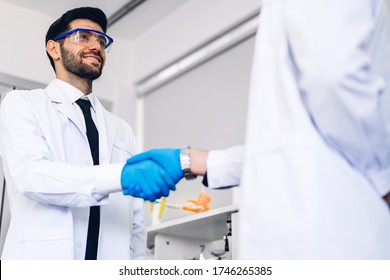 Professional two scientist man working successful deal and making handshake with his partner at laboratory
