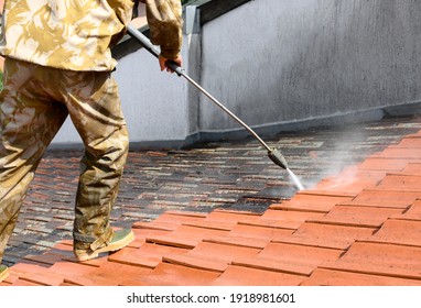 Professional In Uniform Using High Pressure Machine To Clean Rooftop From Dirt And Lichen. Before And After Situation. Clean And Dirty Roof Tiles.