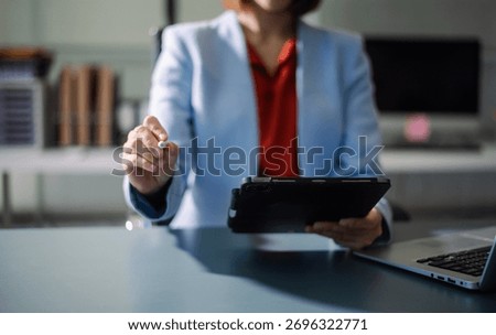 Professional using digital tablet in office, symbolizing technology, innovation, productivity, and teamwork in business communication and digital workflow.