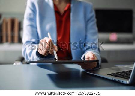 Professional using digital tablet in office, symbolizing technology, innovation, productivity, and teamwork in business communication and digital workflow.