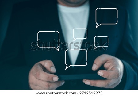 Professional using mobile device with live chat speech bubbles, emphasizing customer service and online communication, phone, and speech bubbles.