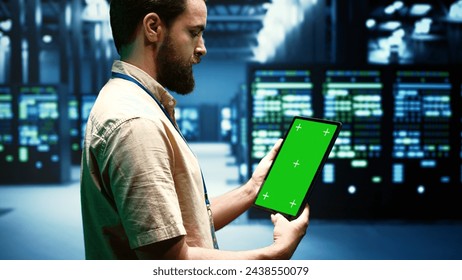 Professional using mock up tablet to check data center configuration settings. Serviceman checking event logs in monitoring software to find busted server farm gadgets root cause