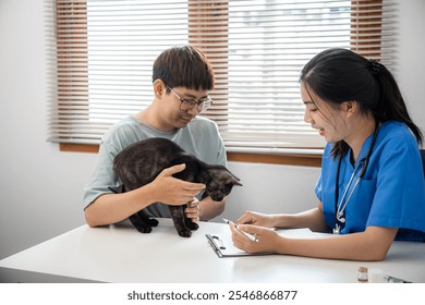 Professional vet doctor helps cat. owner cat holding pet on hands. Cat on examination table of veterinarian clinic. Veterinary care. Vet doctor and cat. - Powered by Shutterstock