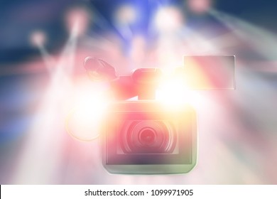 professional video camcorder in studio with blurred lights on stage background