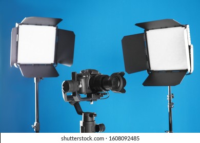 Professional Video Camera And Lighting Equipment On Blue Background