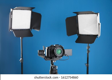 Professional Video Camera And Lighting Equipment On Blue Background