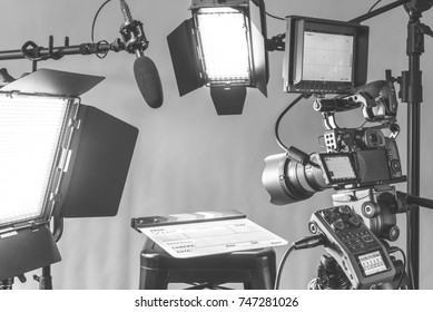 Professional video camera, lights and microphone equipment all set up for an interview in a studio setting.