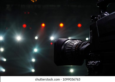 Professional video camera man film concert on stage.Big pro 4k video cam shoots live broadcast footage for television.TV camera operator shooting videos on concert stage