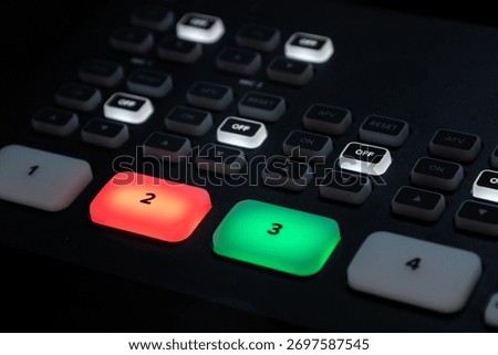Professional video switcher and software control panel in audiovisual production setup with glowing buttons and screens.