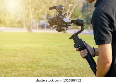 Professional videographer with camera on gimbal stabilizer for taking production