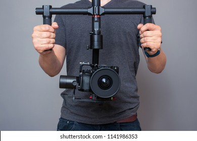 Professional videographer holding gimbal with digital camera
