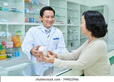 Professional Vietnamese Pharmacist Telling Benefits Of New Medicine To The Customer