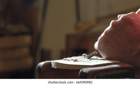 The professional violin master makes a violin with his own hands, uses a pure tree spruce, pine, makes patterns from a chisel, plane. Concept spiritual instrument, made hands, art, music, melody sound