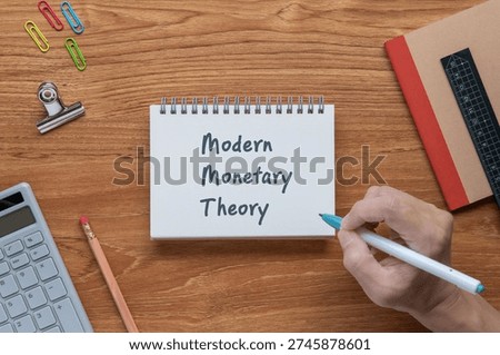 Professional visualization of Modern Monetary Theory on notebook with calculator, clips, pen. Financial and economic strategic background.