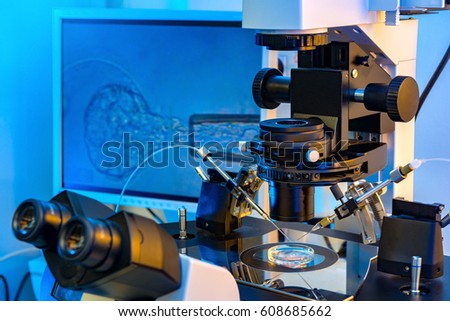 A Professional In Vitro Fertilisation Microscope with A Monitor in Background