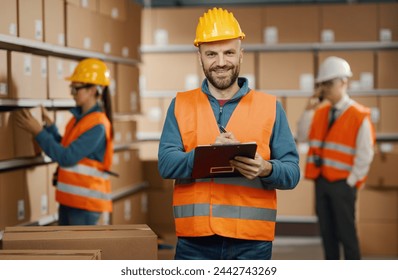 Professional warehouse worker posing with a safety helmet and holding a clipboard, logistics and shipment concept - Powered by Shutterstock