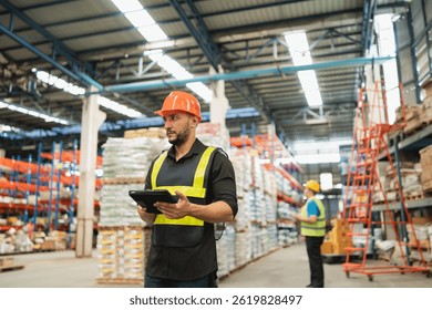 Professional Warehouse Worker Using Tablet for Inventory Management in Modern Distribution Center