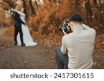 Professional wedding photographer in action. the bride and groom in nature in autumn