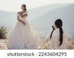 Professional wedding photographer making pictures of bride and groom on the wedding day. Wedding photography planning concept. Portrait photoshoot. Designer dresses fashion