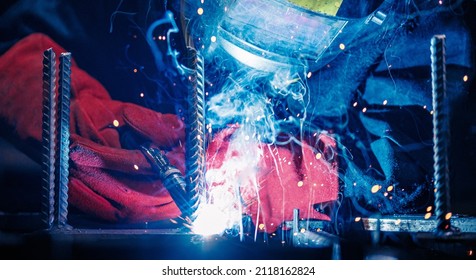Professional welder erecting metal steel. Banner Factory industrial worker in workplace with spark.