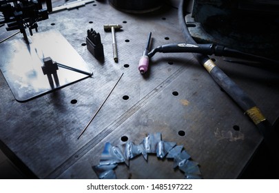 Professional Welder Tools On Table In Workshop.Specialized Tool Kit For Welding Metal Parts With Electrical Torch.Industrial Warehouse For Skilled Work