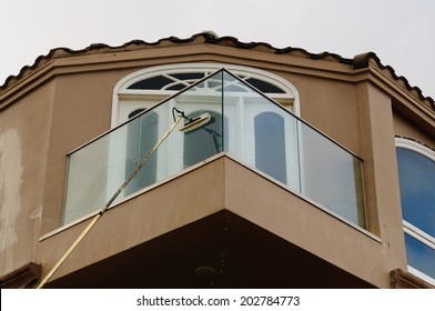  Professional Window Washer Cleaning House Windows With De-ionized Water Using An Extension Pole