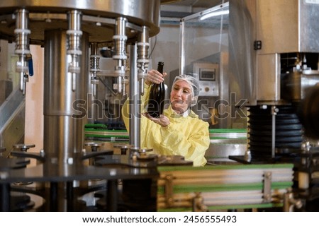 Professional winemaker controlling wine making process and quality at winery factory