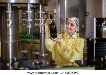 Professional winemaker controlling wine making process and quality at winery factory