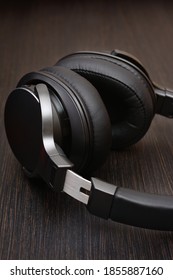 Professional Wireless Headphones Close-up. Against The Dark Wood Countertop