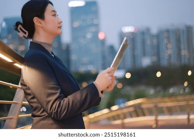 Professional Woman in Business Attire Engaged in Work in City at Dusk - Powered by Shutterstock