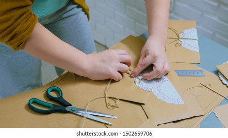 Professional woman decorator, designer working with kraft paper and wrapping envelope at workshop, studio. Decorating, handmade and art concept - Powered by Shutterstock