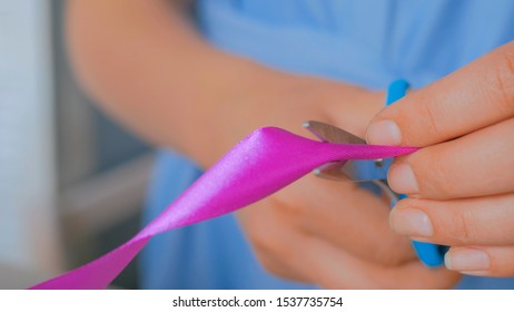Professional woman floral artist, florist cutting ribbon of wedding bouquet at workshop, flower shop. Close up shot. Floristry, handmade and small business concept