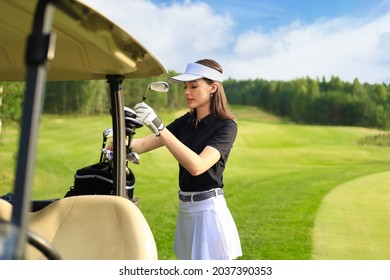 Professional woman golf player choosing the golf club from the bag - Powered by Shutterstock