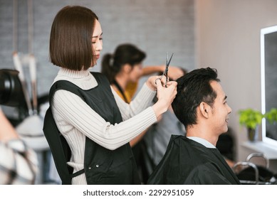 Professional woman hair stylish hsir cutting on asian man in hair salon, Small business in the town. - Powered by Shutterstock