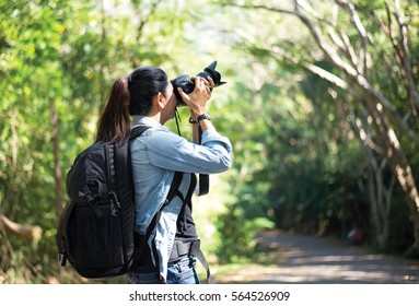 Professional woman photographer taking camera outdoor portraits with prime lens in the photography nature. Greenery tone 2017.  Travel and Lifestyle Concept - Shutterstock ID 564526909