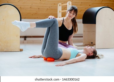 Professional Woman Physical Therapist Workout With Client Doing Massage Technique Applying Balls For Pelvis Or Hip On Sacroiliac Joint Pain Area Pain Relief, Lying On Floor In Pilates Studio.