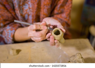 Professional woman potter making ceramic souvenir penny whistle toy bird in pottery workshop, studio. Crafting, artwork and handmade concept - Powered by Shutterstock