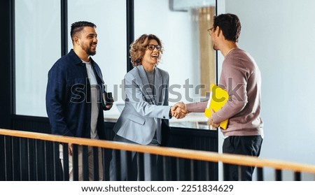 Professional woman shaking hands with a new employee in an office. Happy business woman hiring a job candidate. Business people forming a new partnership in a startup.