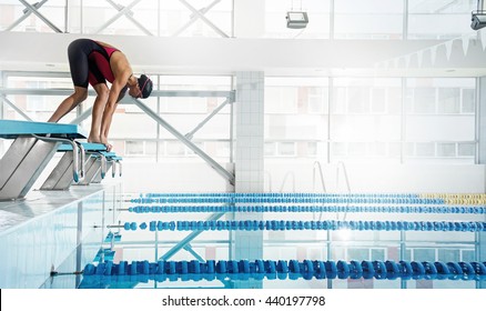 Professional woman swimmer in a starting position 