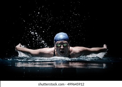 Professional woman swimmer swim using breaststroke technique on the dark background