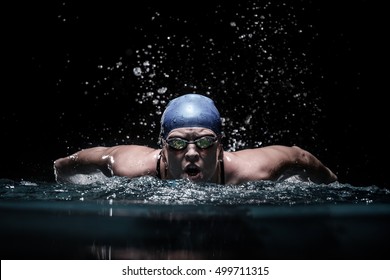 Professional woman swimmer swim using breaststroke technique on the dark background