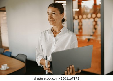 A Professional Woman Working in a Modern Office Environment with Her Laptop Computer - Powered by Shutterstock