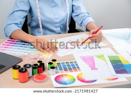Professional women fashion designer stylist working and thinking decide making new clothes collection material product and choosing a color swatch.