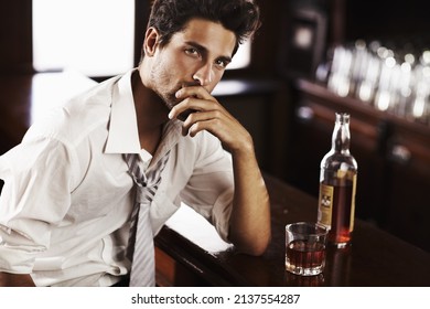 Professional At Work, Sophisticated After It - Modern Living. A Handsome Young Man Winding Down After Work With A Drink At The Bar.