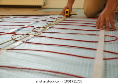 Professional Worker Installing Electric Underfloor Heating System Indoors, Closeup