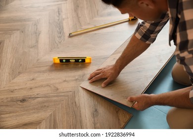 Professional worker installing new parquet flooring indoors, closeup - Shutterstock ID 1922836994